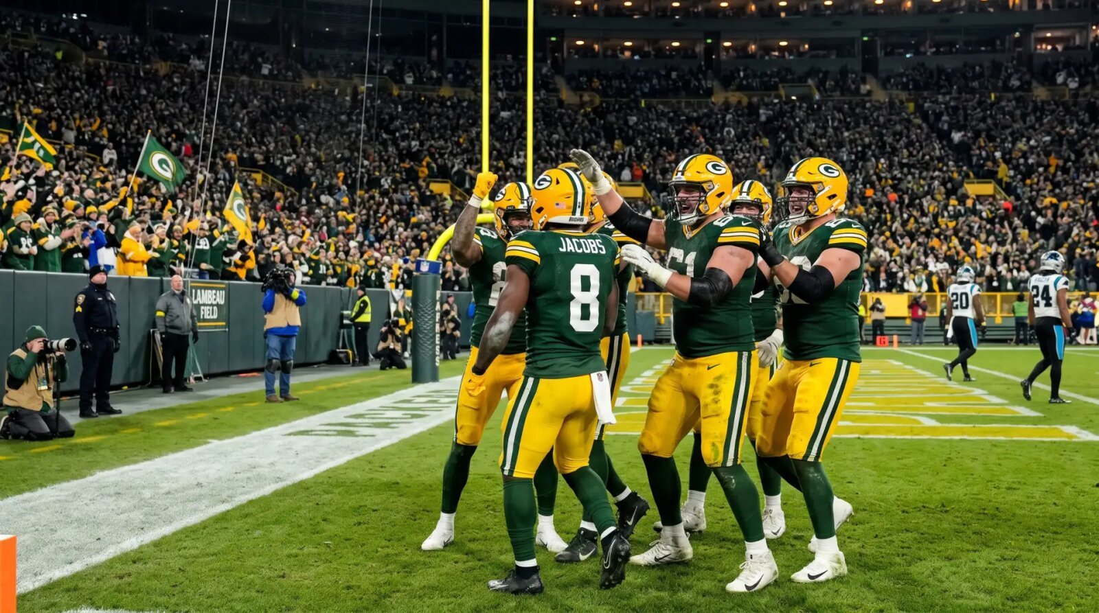 Green Bay Packers running back Josh Jacobs celebrates with teammates after scoring a touchdown against the Carolina Panthers at Lambeau Field.